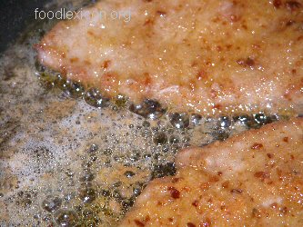 Braten. Hier braten Kalbsschnitzel in schäumender Butter.